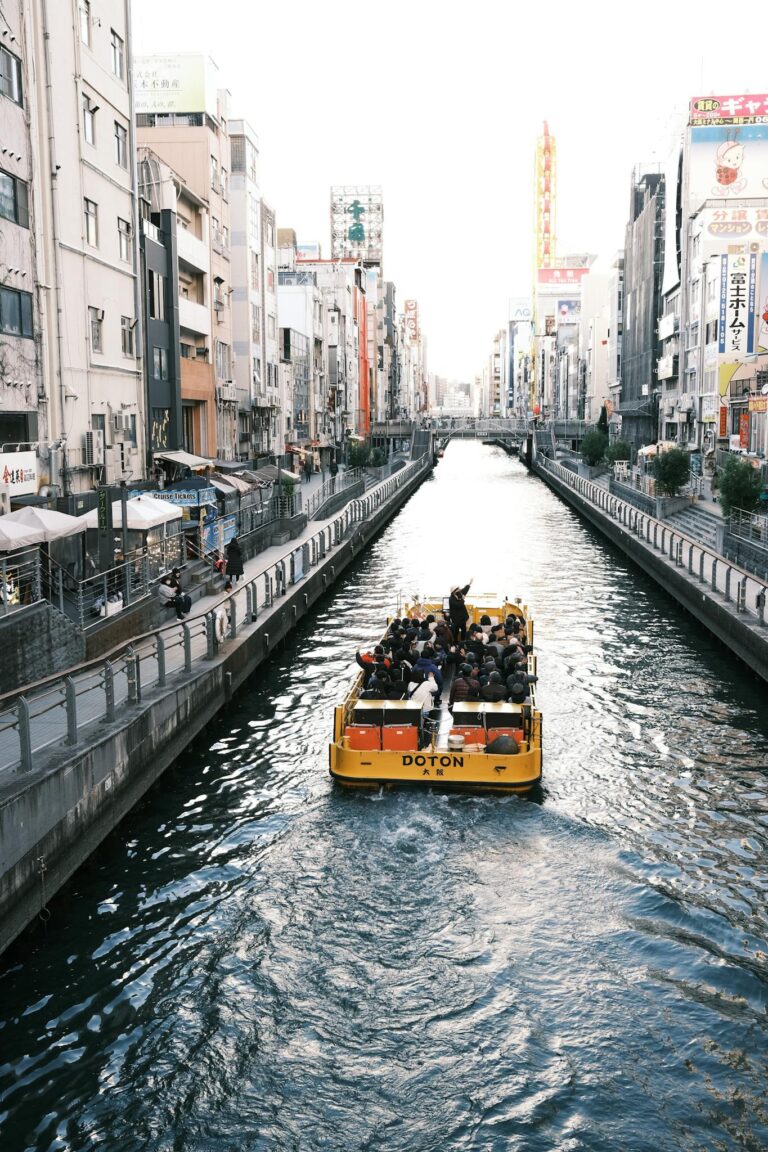 Explore Osaka's vibrant Dotonbori Canal with a scenic boat tour showcasing the city's urban charm.