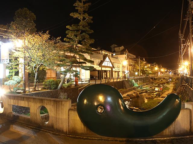 Lantern-lit riverside street of Tamatsukuri Onsen at night